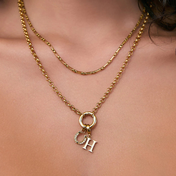 Gold necklace with a pendant on a person's neck