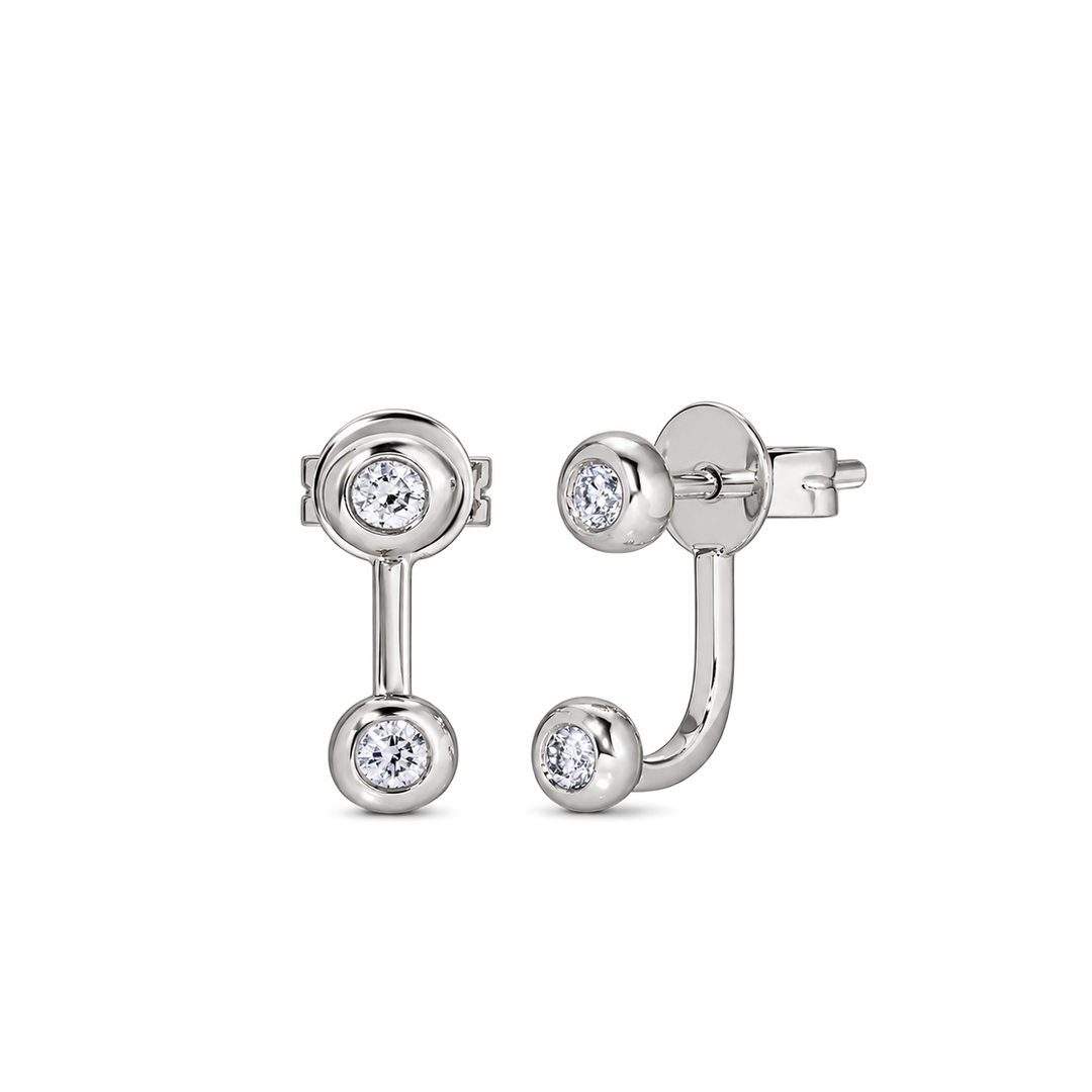 A pair of silver-toned labret earrings with round bezel-set clear gemstones, shown from front and side angles on a plain white background.