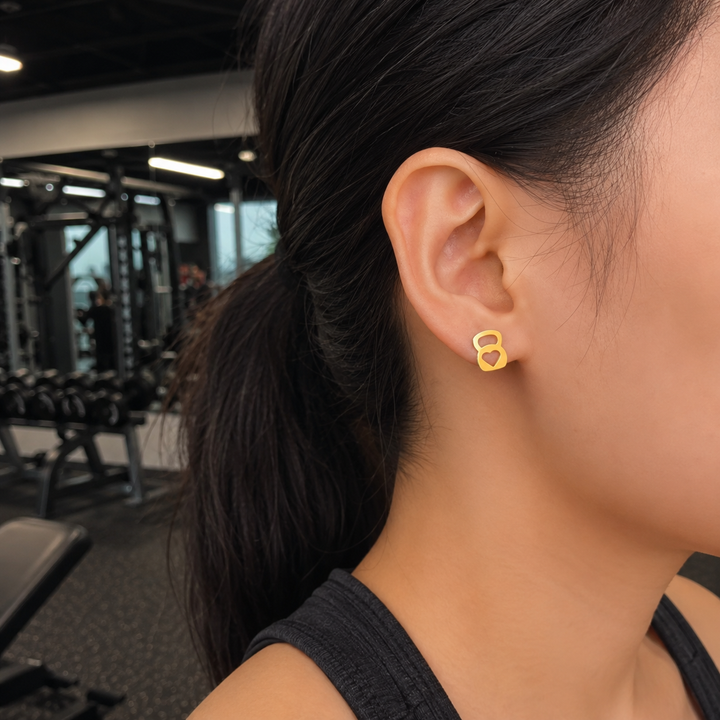 Person wearing gold earrings in a gym setting