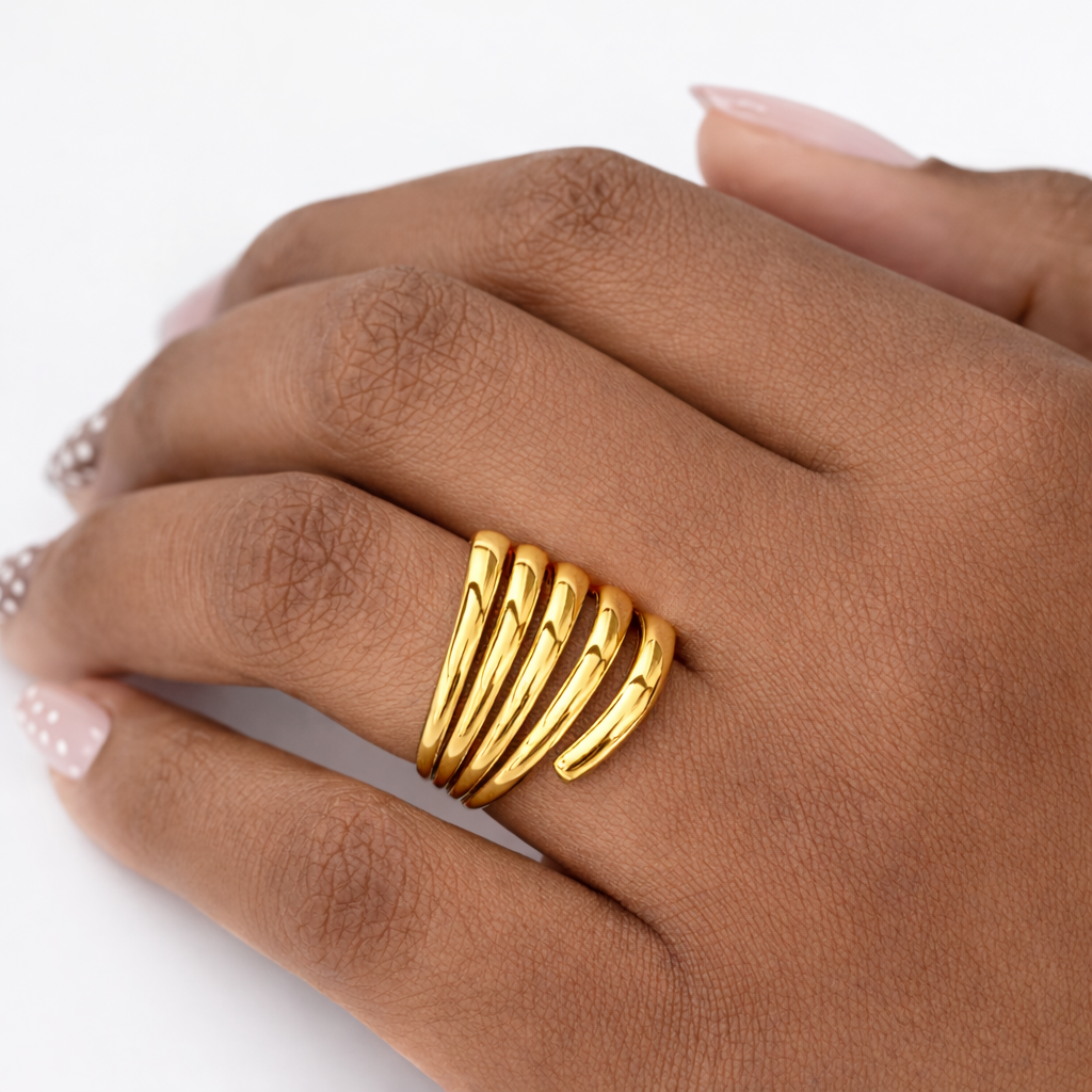 Gold ring with multiple bands on a hand against a white background