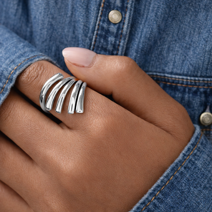 Silver ring on a finger with a denim background
