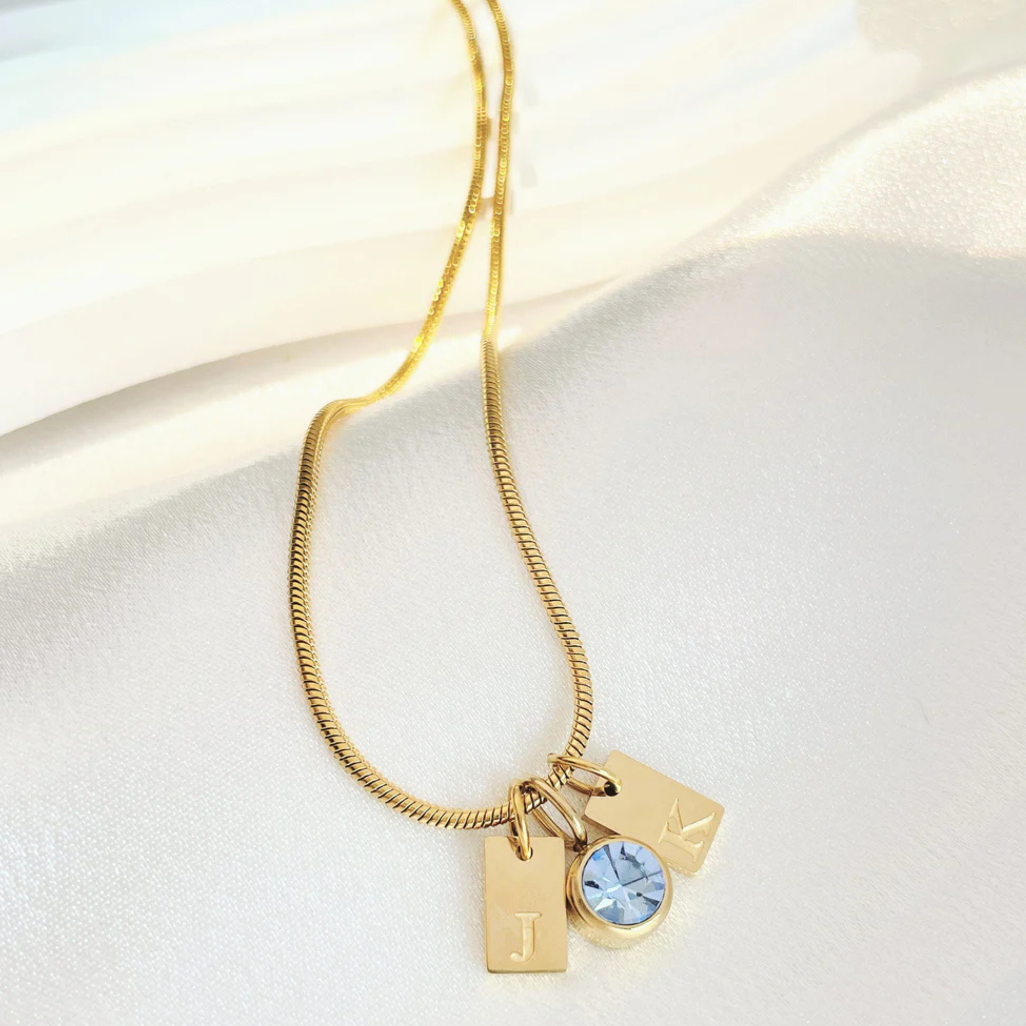 Gold necklace with charms on a white background