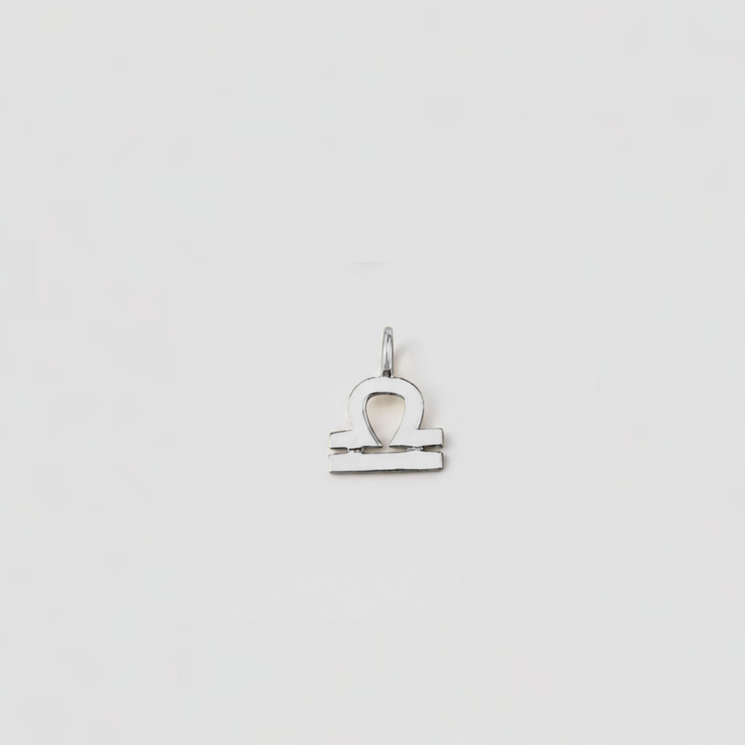 Silver Libra zodiac sign pendant on a light gray background