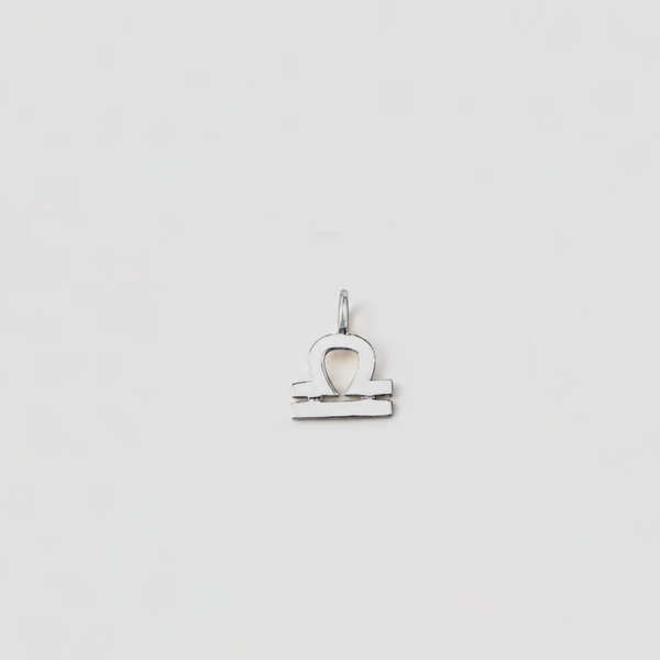 Silver Libra zodiac sign pendant on a light gray background