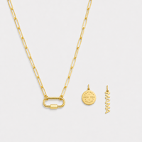 Gold necklace with two pendants on a light gray background