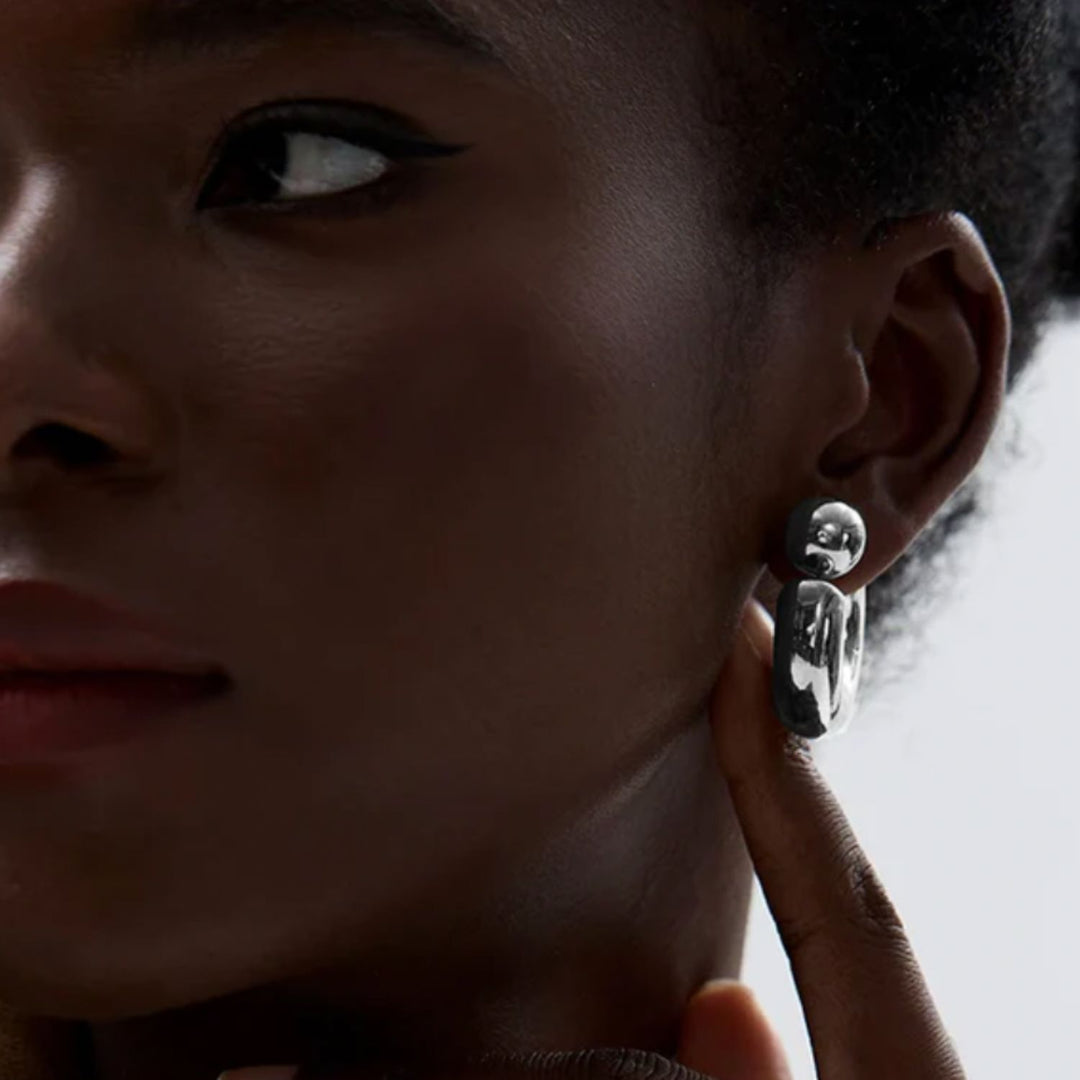 Close-up of a person wearing a unique silver earring.
