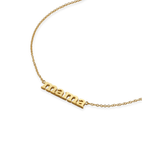 Gold necklace with 'mama' pendant on a white background