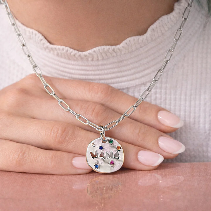 Silver necklace with a 'MAMA' pendant on a hand