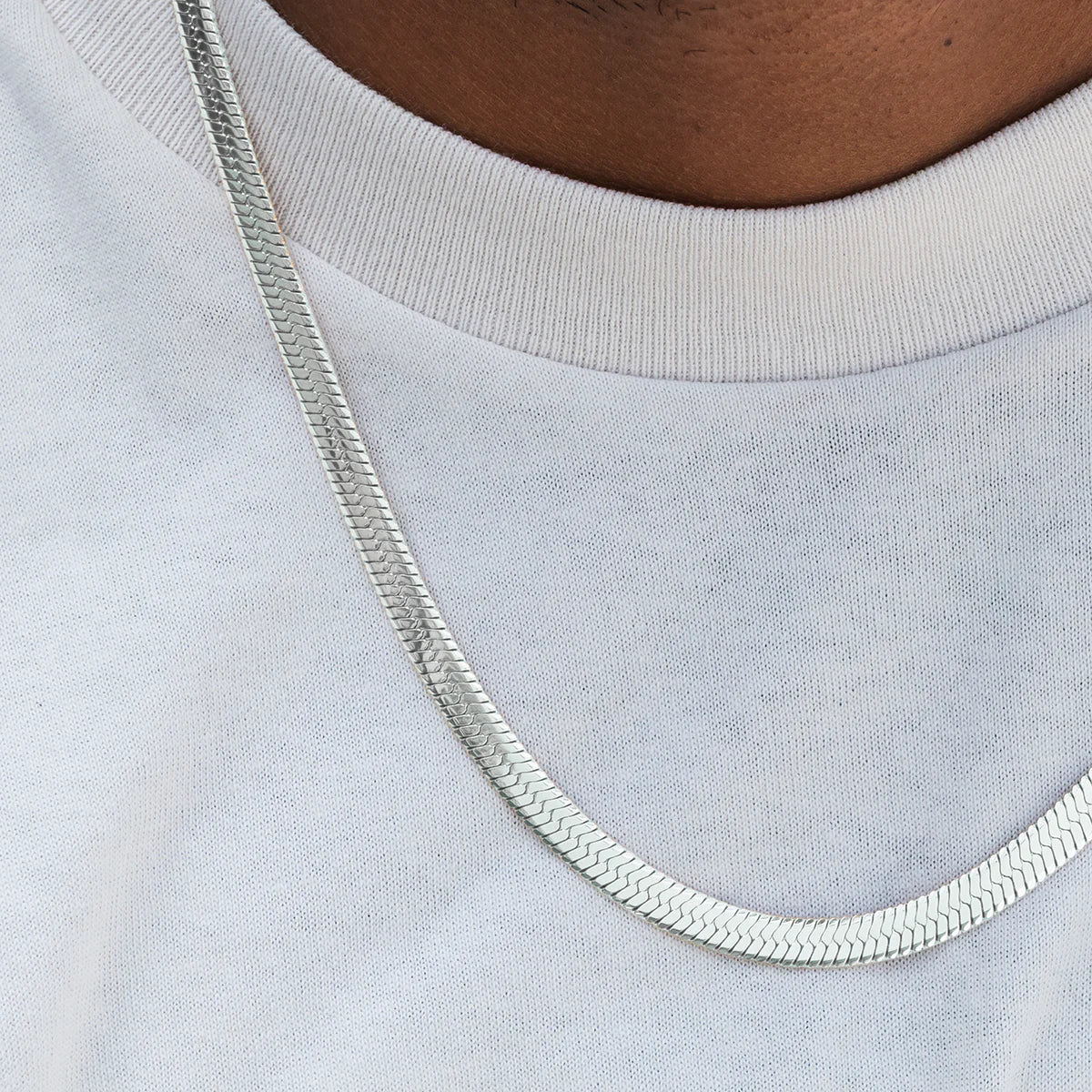 Silver chain necklace on a light gray shirt