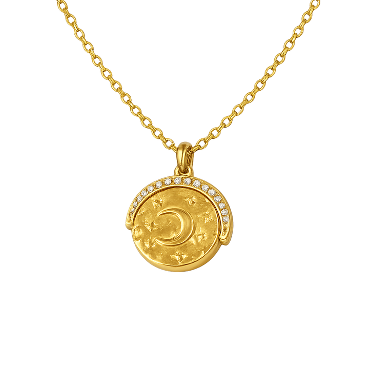 Gold necklace with a round pendant featuring a moon design on a white background