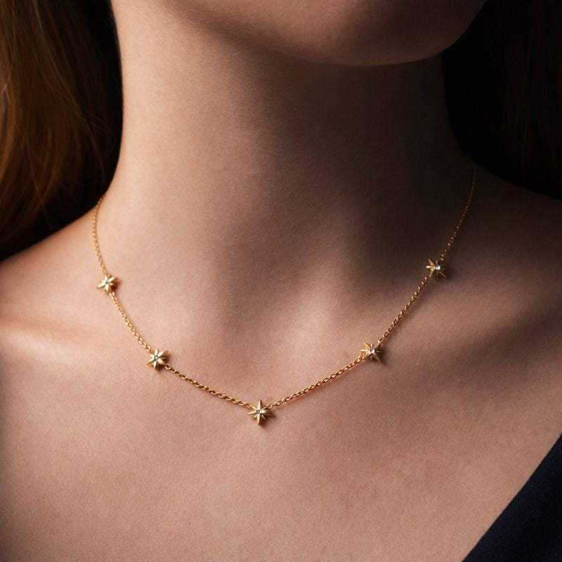 Gold necklace with star pendants on a person's neck