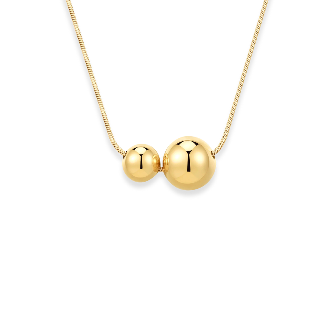 Gold necklace with two round pendants on a white background