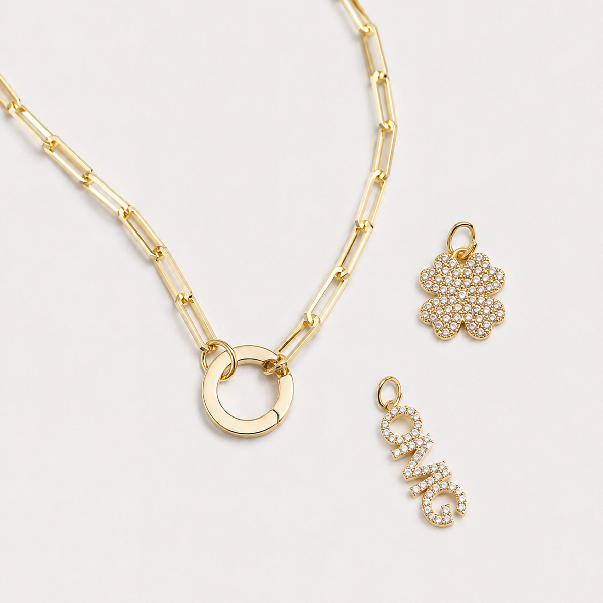 Gold necklace and earrings on a light gray background
