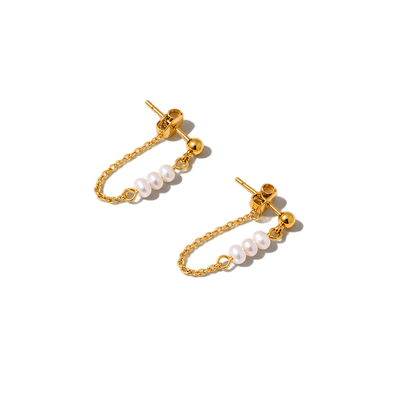 A pair of gold-toned dangle earrings with small white pearl beads on a chain, photographed on a plain white background.