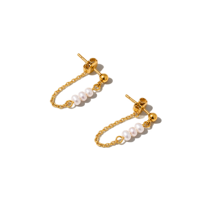 A pair of gold-toned dangle earrings with small white pearl beads on a chain, photographed on a plain white background.