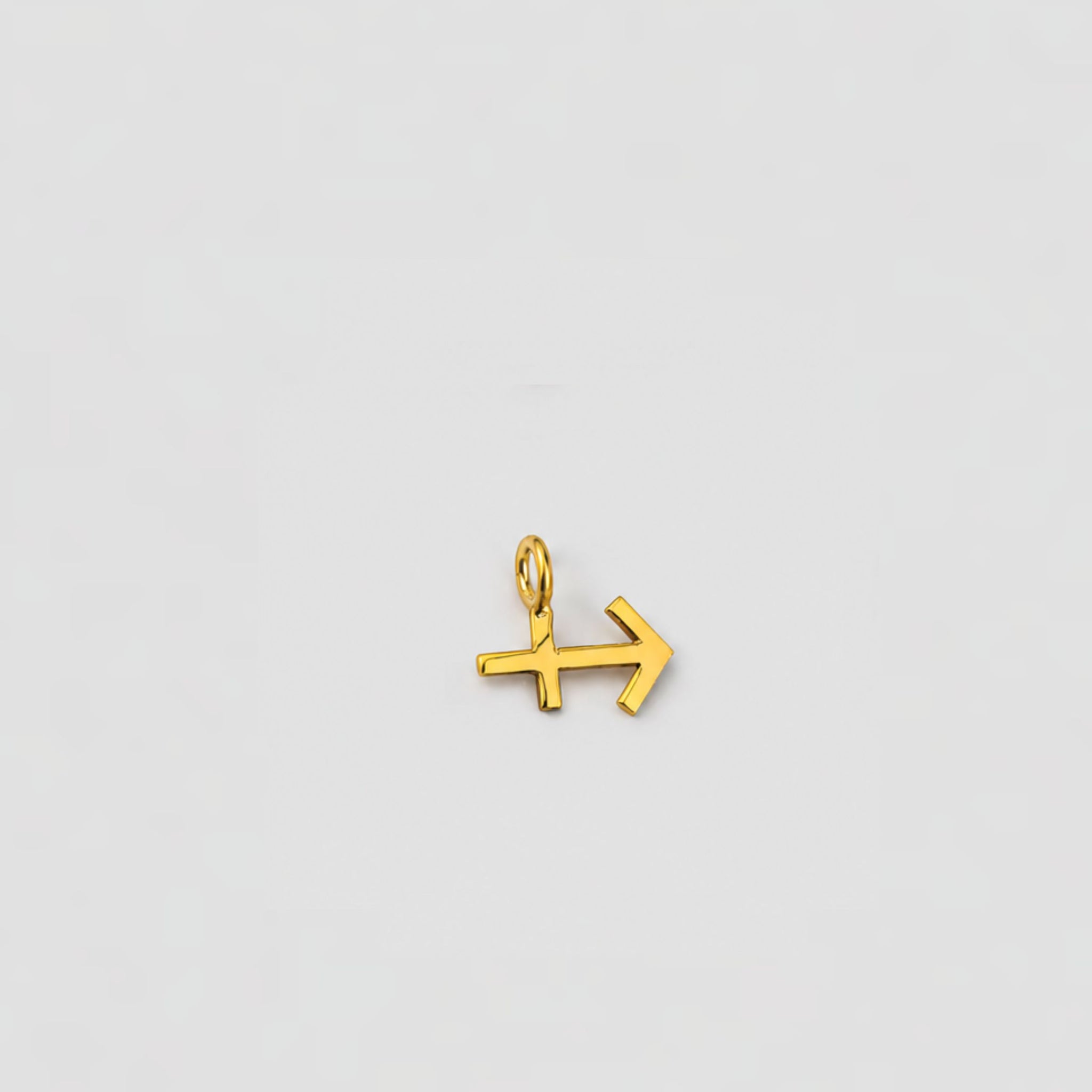 Gold arrow-shaped pendant on a light gray background sagittarius charm