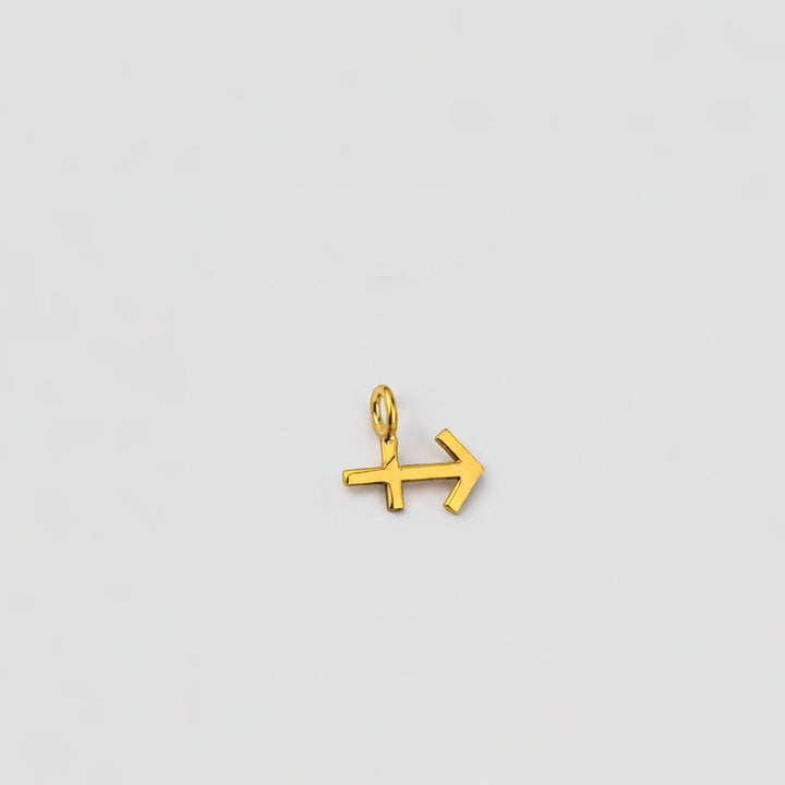 Gold arrow-shaped pendant on a light gray background sagittarius charm
