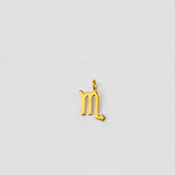 Gold scorpio zodiac pendant on a light gray background