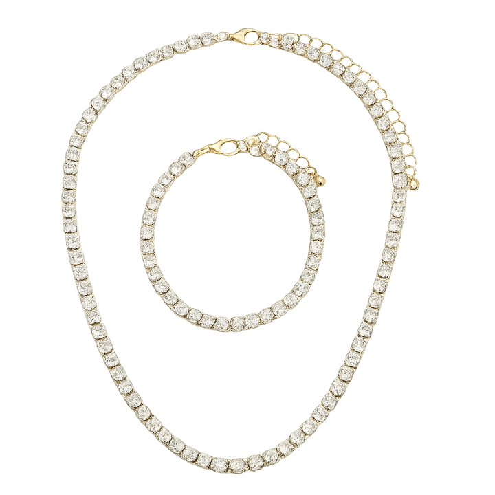 Gold necklace and bracelet set with clear gemstones on a white background