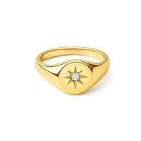 Gold ring with star design and diamond on a white background