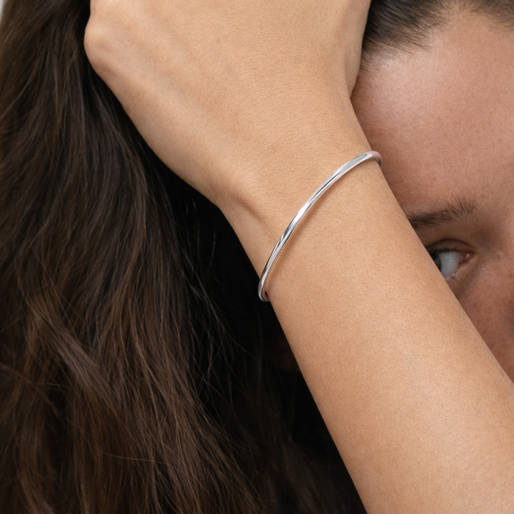 Silver bracelet on a person's wrist with a blurred background