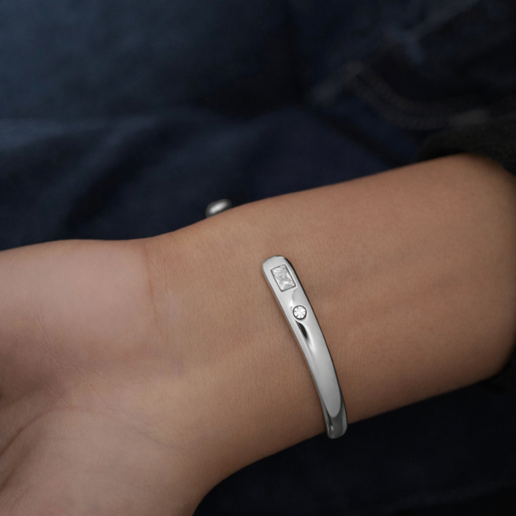 Silver bracelet on a wrist with a dark background