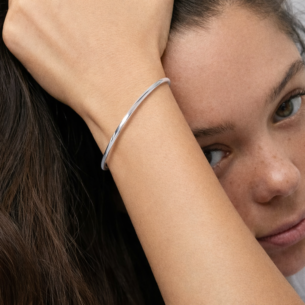 Woman wearing a silver bracelet with a neutral background