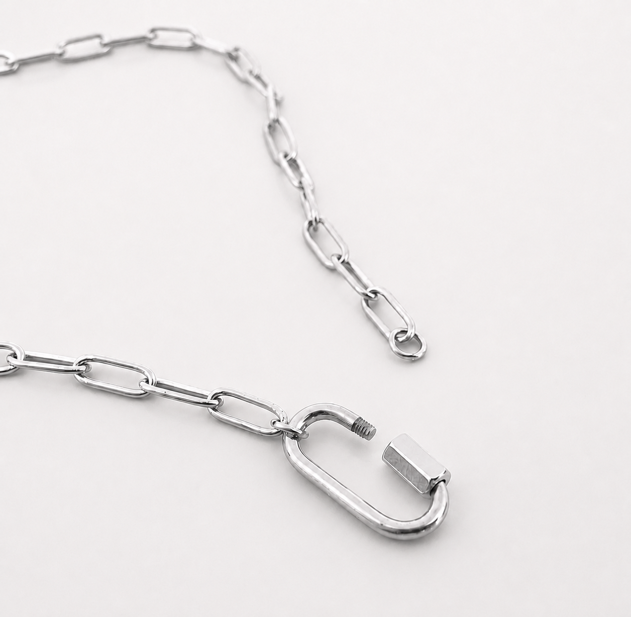 Silver chain with a carabiner on a white background