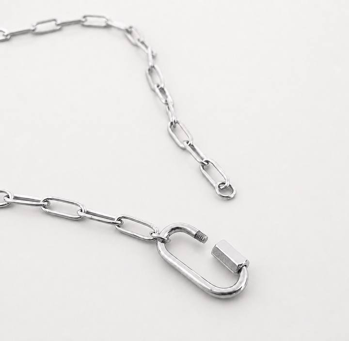 Silver chain with a carabiner on a white background