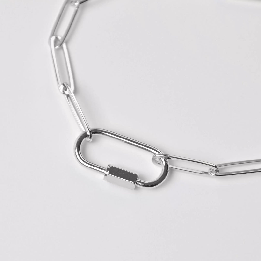 Silver chain necklace on a light gray background