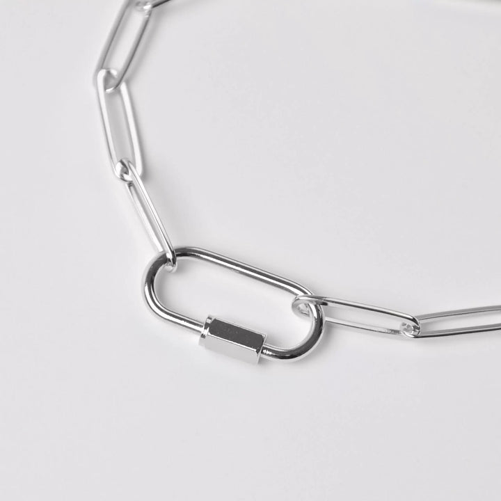 Silver chain necklace on a light gray background