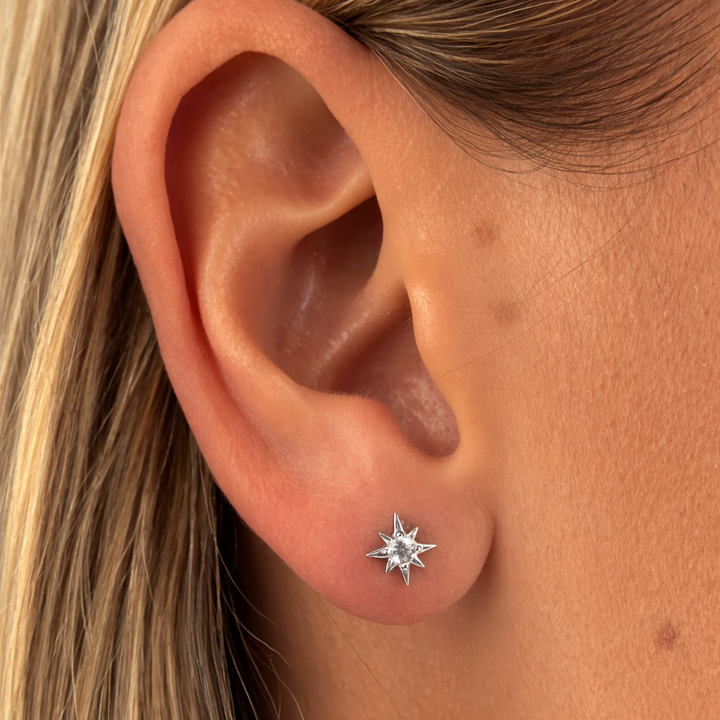 Close-up of an ear wearing a star-shaped silver earring.