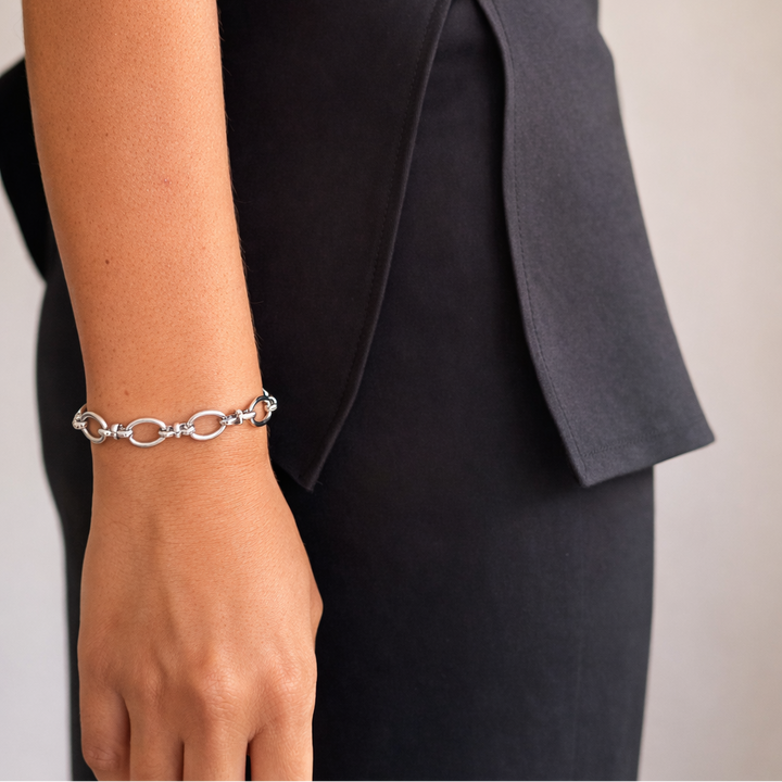 Silver bracelet on a person's wrist with a blurred background