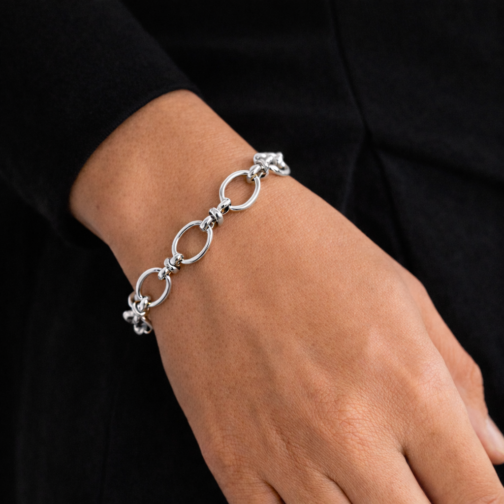 Silver bracelet on a wrist against a black background