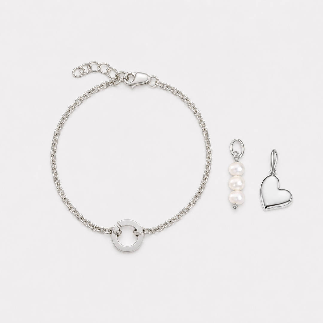 Silver bracelet and heart-shaped pendant on a white background