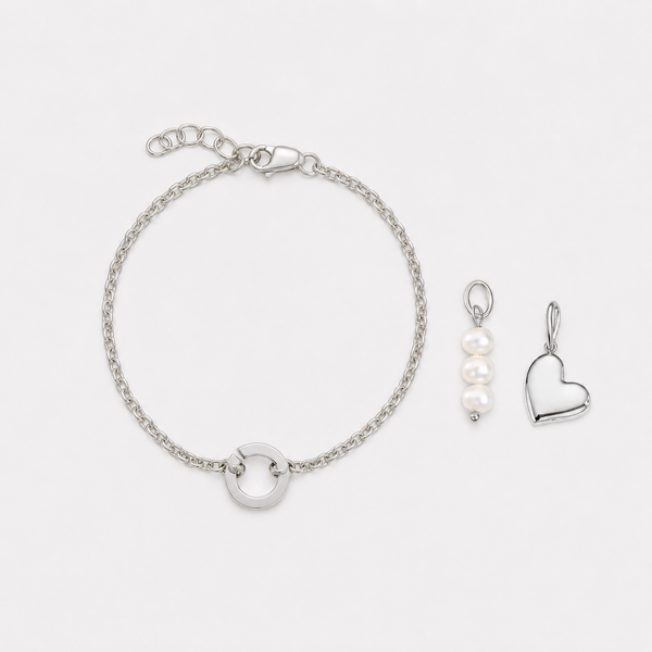 Silver bracelet and heart-shaped pendant on a white background