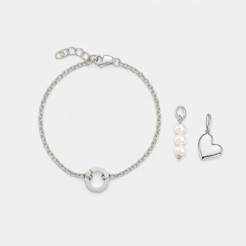 Silver bracelet and heart-shaped pendant on a white background