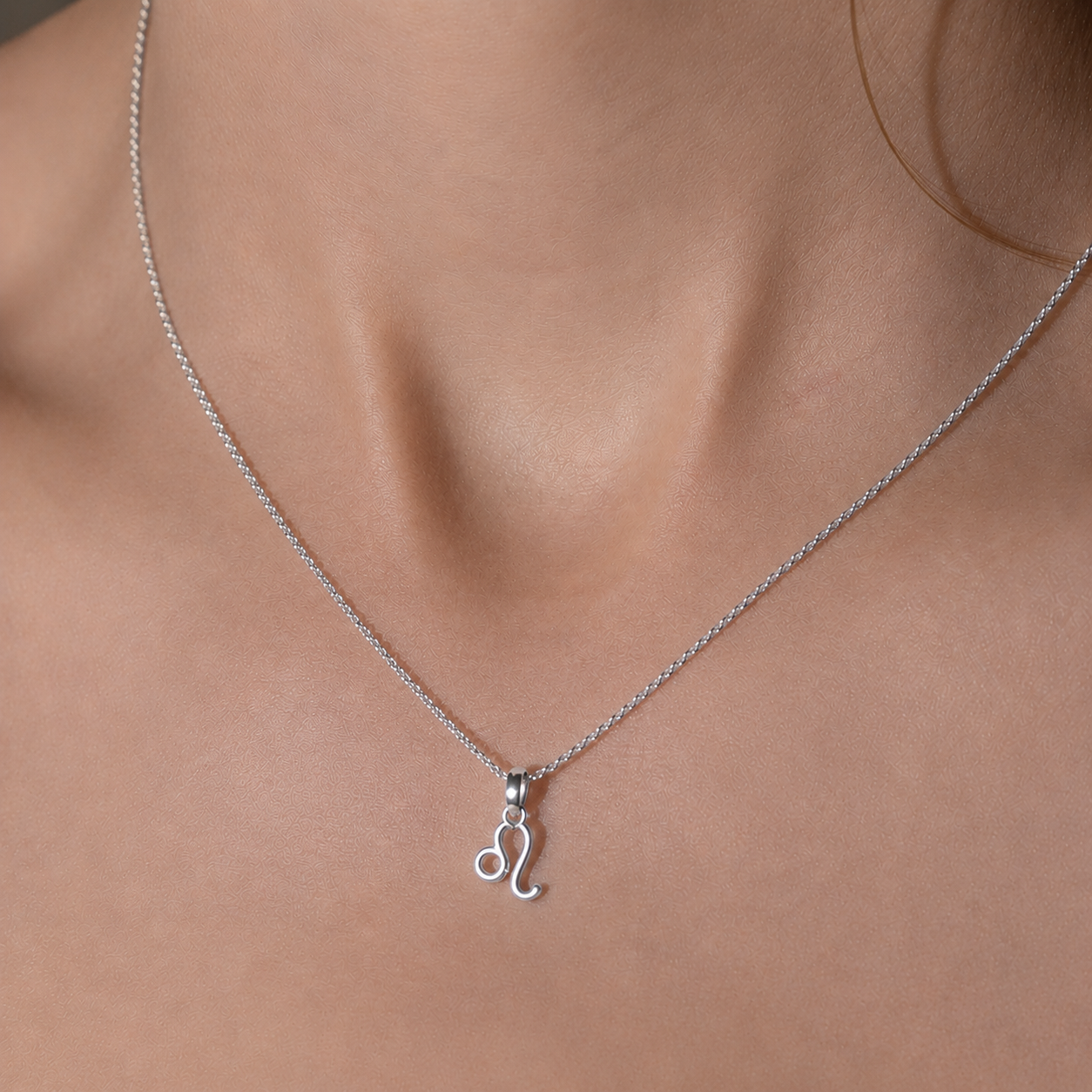 Silver necklace with a pendant on a person's neck