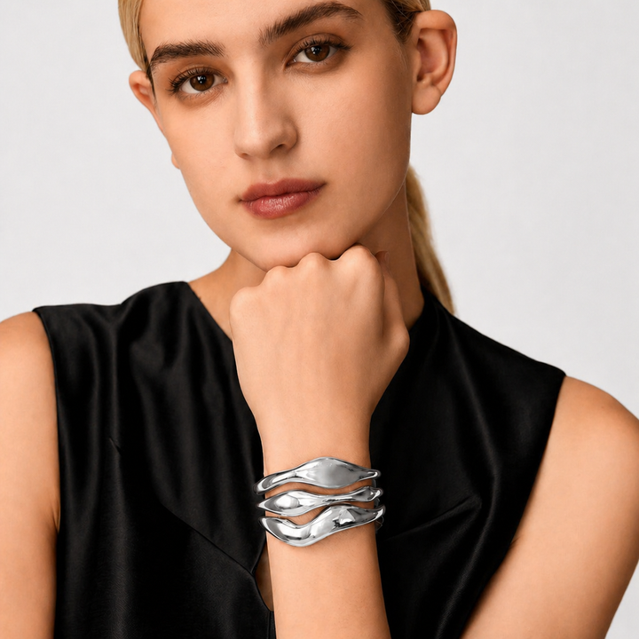 Woman wearing a silver bracelet on a plain background