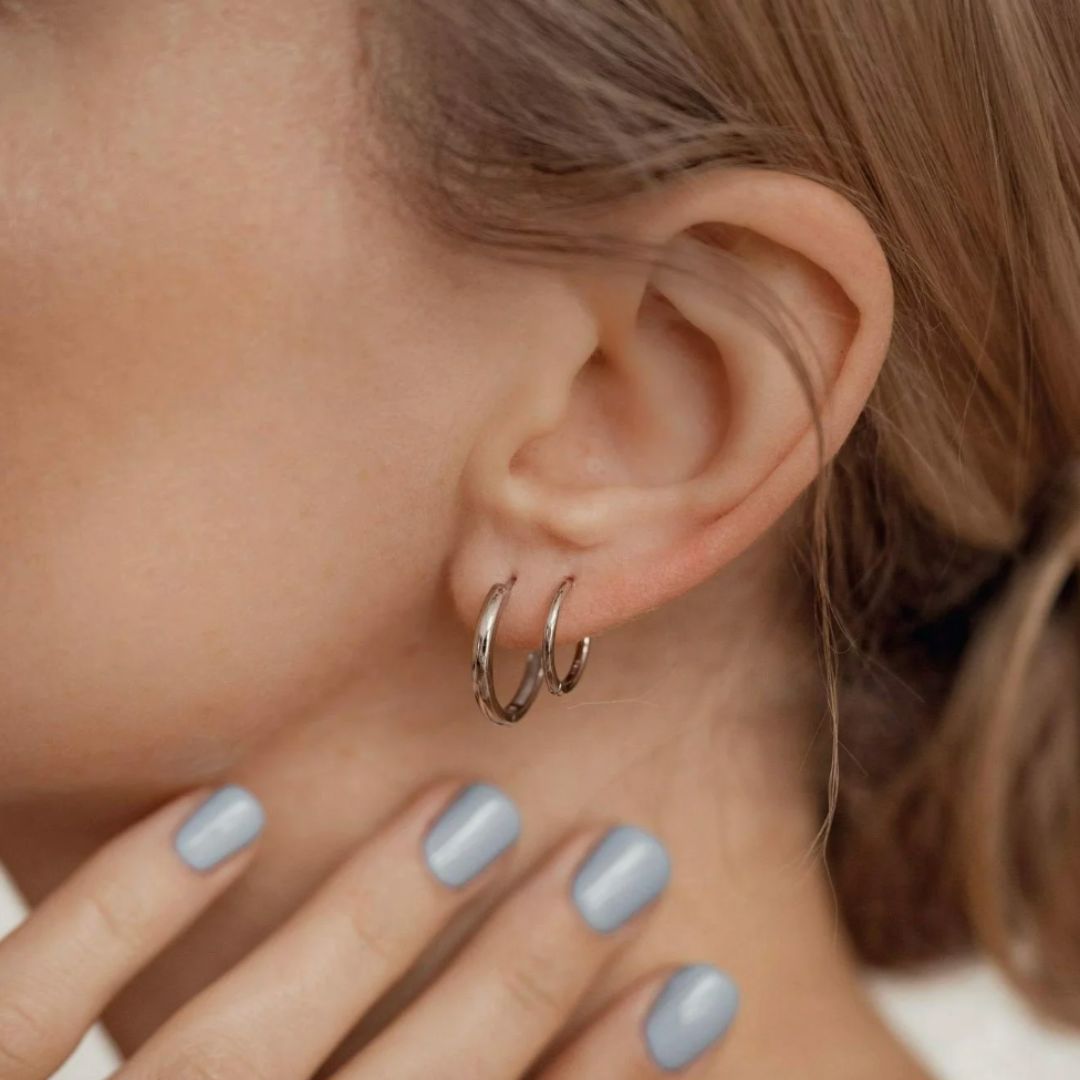 Close-up of an ear wearing a double hoop earring with a blurred background
