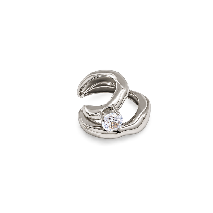 A silver-toned abstract wave-shaped ring with a single round clear gemstone, shown on a plain white background.