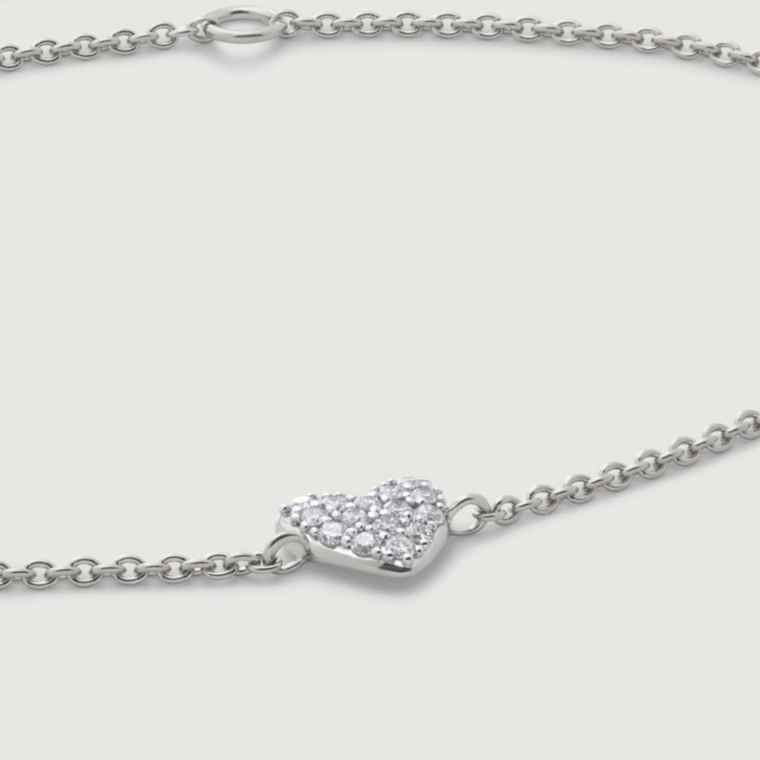 Silver bracelet with a heart-shaped clasp on a light gray background