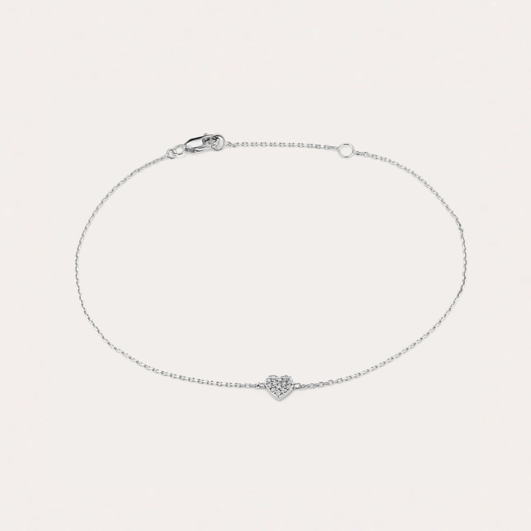 Silver bracelet with a heart-shaped clasp on a light gray background