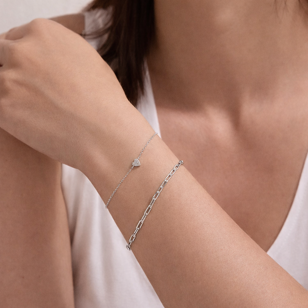 Silver bracelet on a person's wrist with a plain background