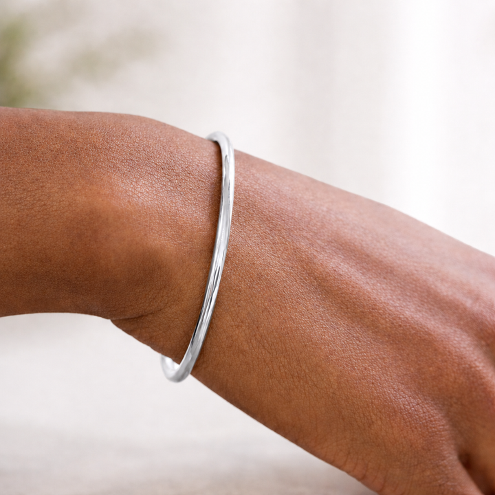 Silver bracelet on a wrist with a blurred background