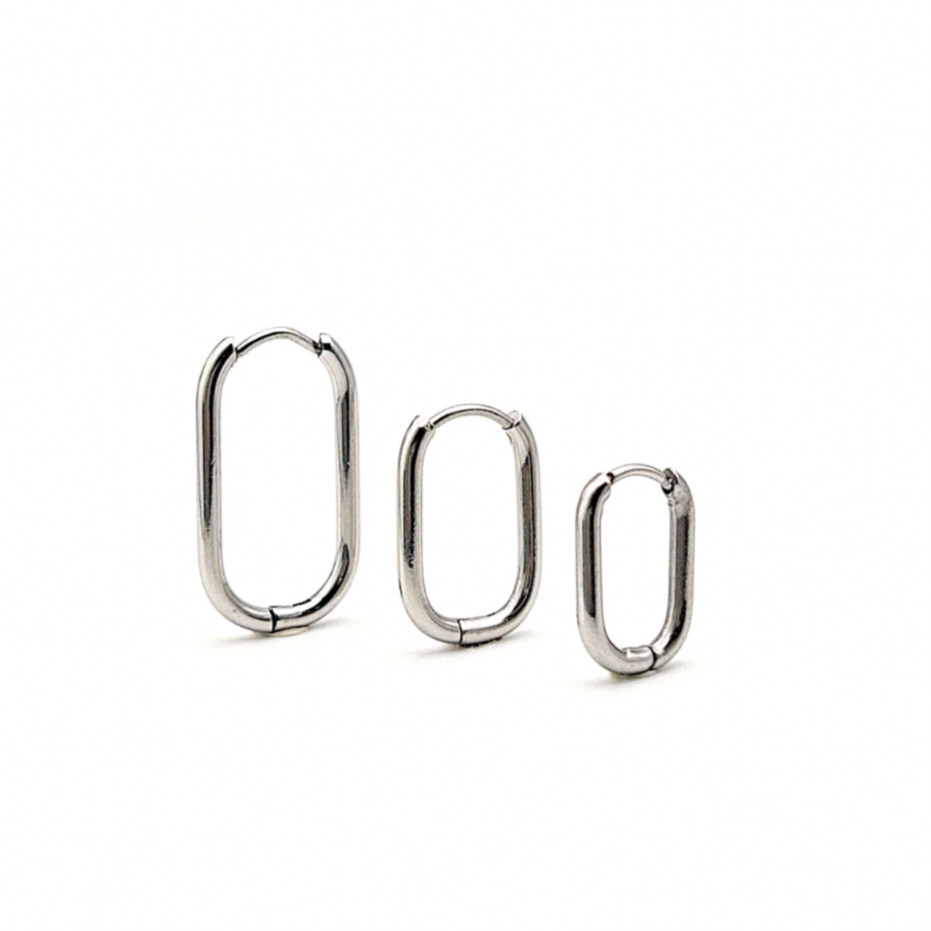 Three silver hoop earrings of different sizes on a white background