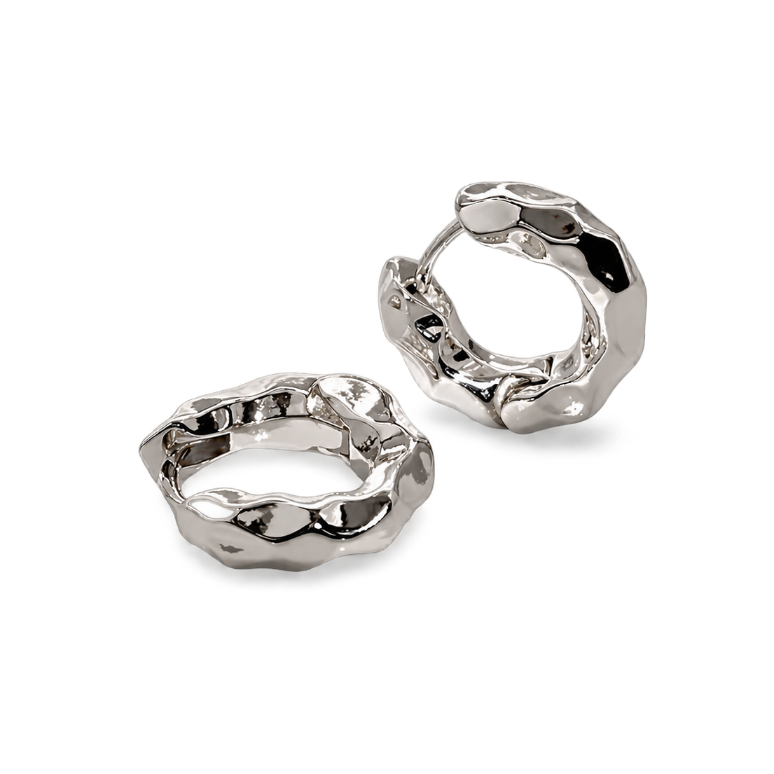 A pair of chunky, textured silver huggie hoop earrings with a polished, organic, hammered finish, displayed on a clean white background.