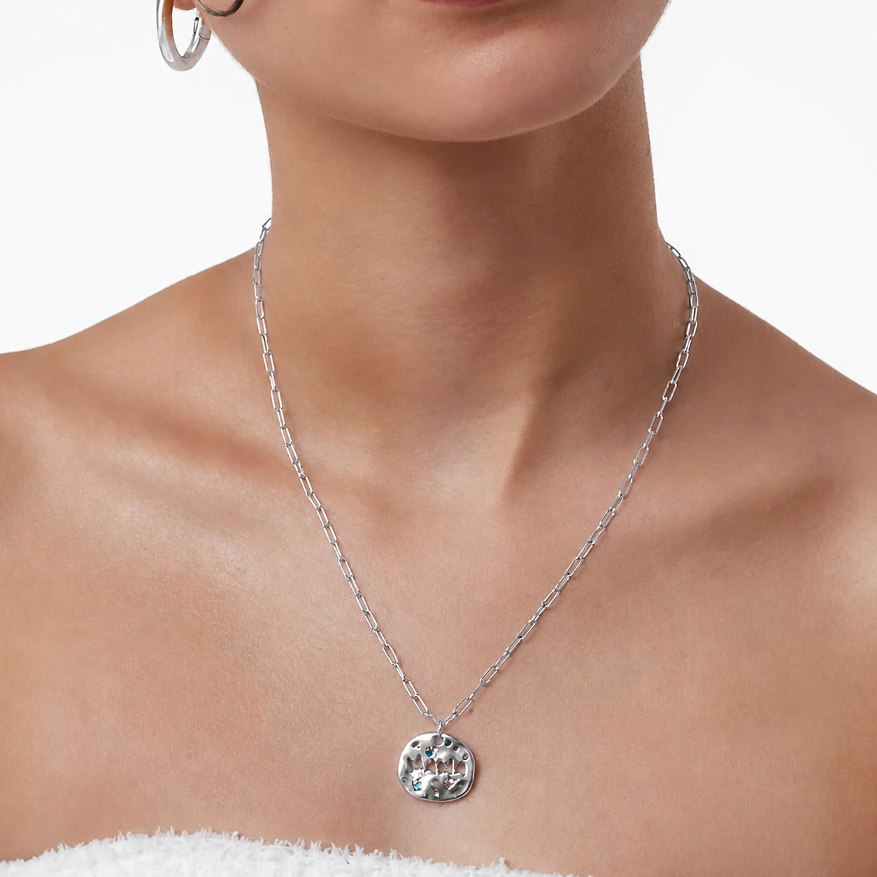 Silver necklace with a pendant on a model against a white background