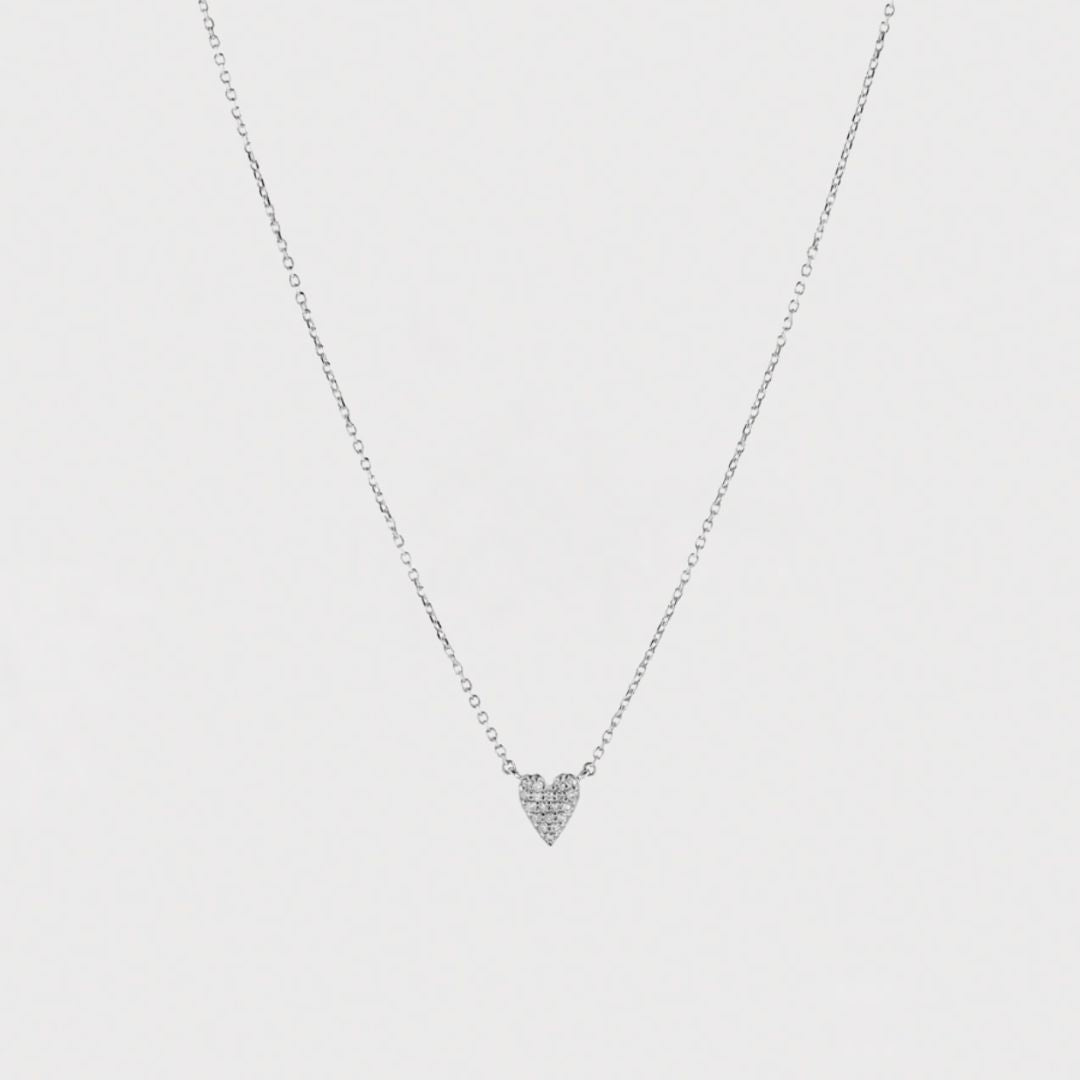 Heart-shaped necklace with small diamonds on a light gray background