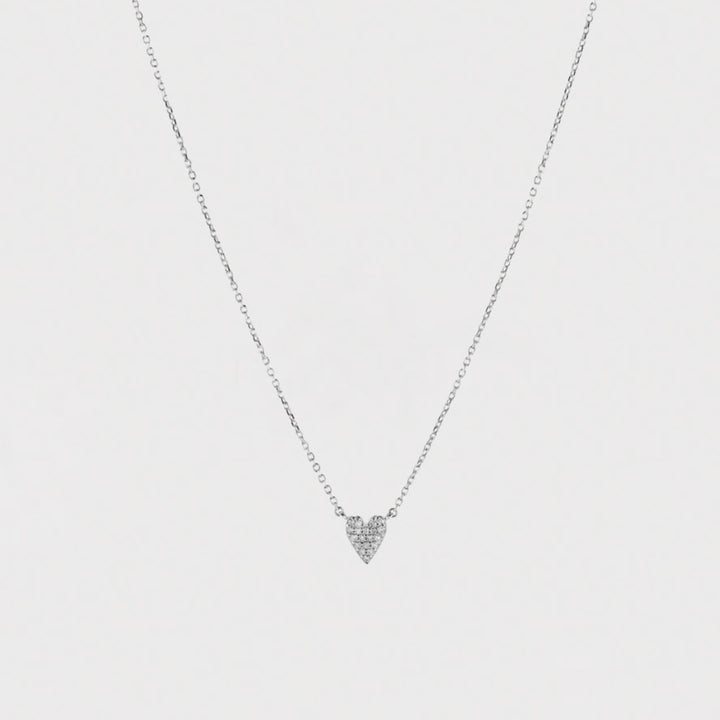 Heart-shaped necklace with small diamonds on a light gray background